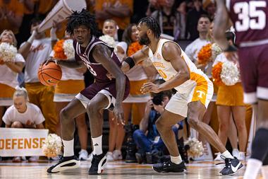 Texas A&M forward Solomon Washington, left, works for a shot as he is defended by Tennessee...