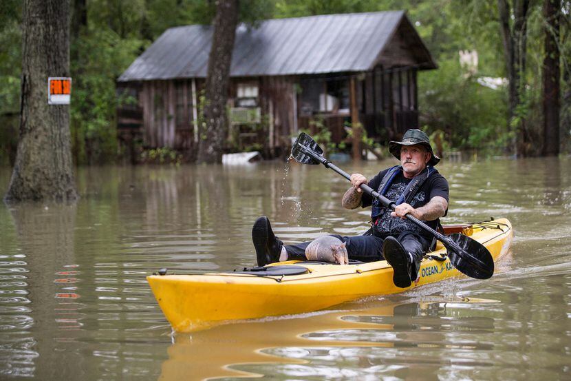 Donnie McCulley paddles out from a flooded neighborhood caused by heavy rain spawned by...