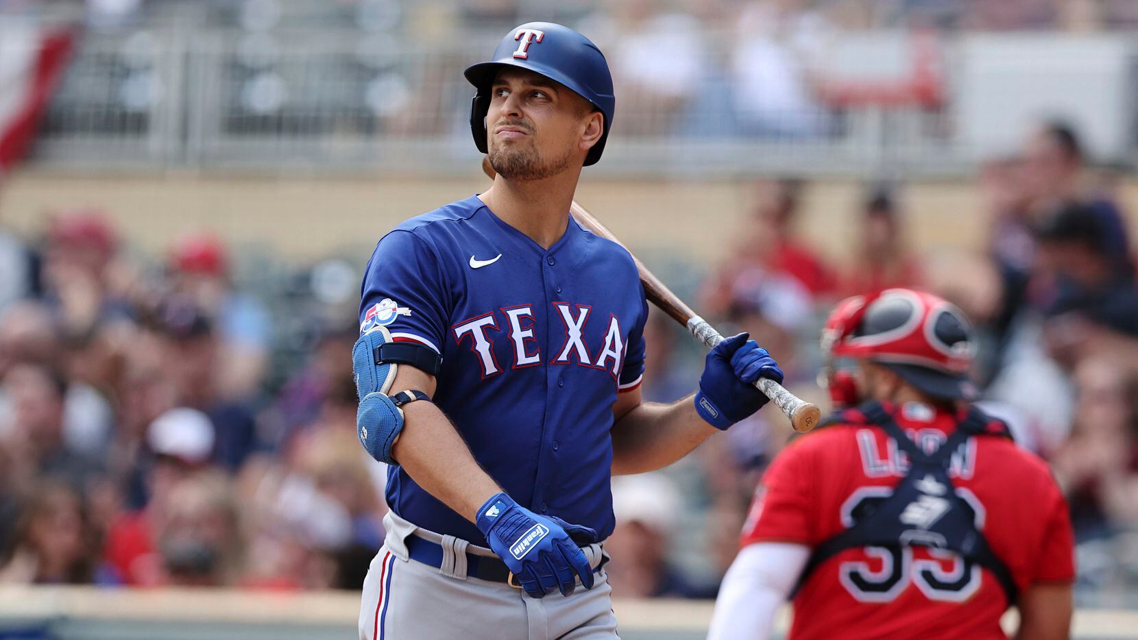 Texas Rangers' Nathaniel Lowe reacts after striking out during the first inning of a...