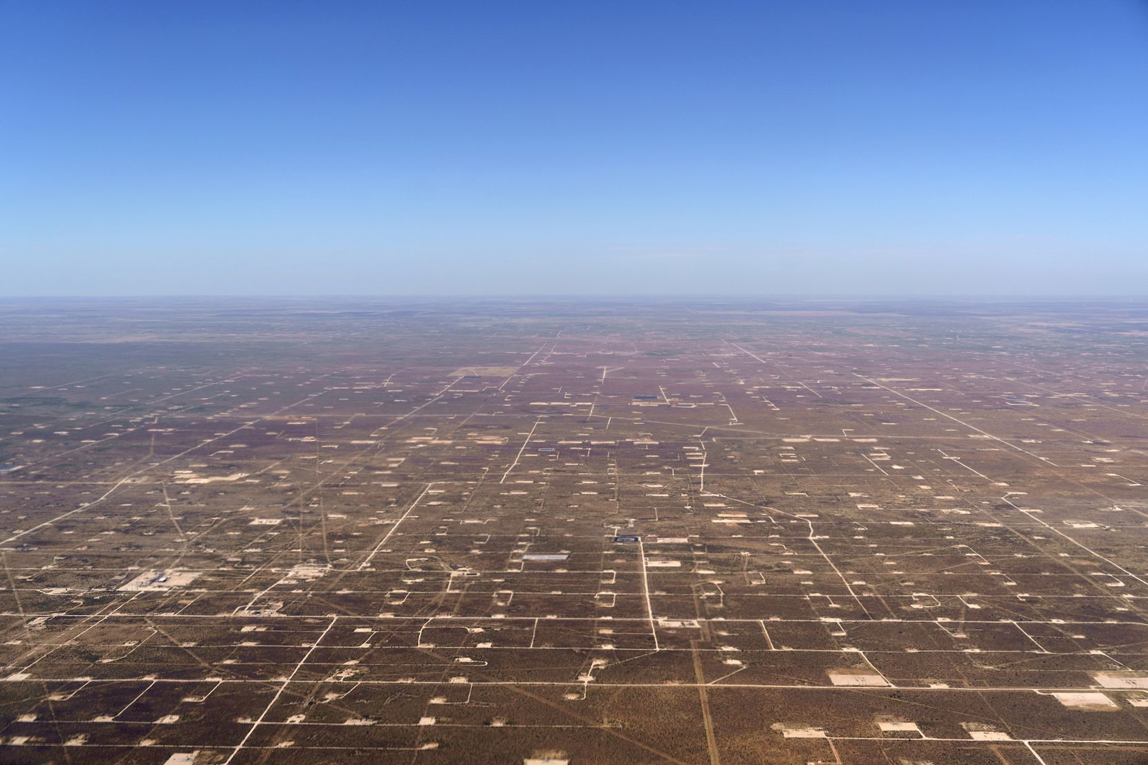 Patches of land housing oil pumpjacks dot the landscape of the Permian Basin in Midland....