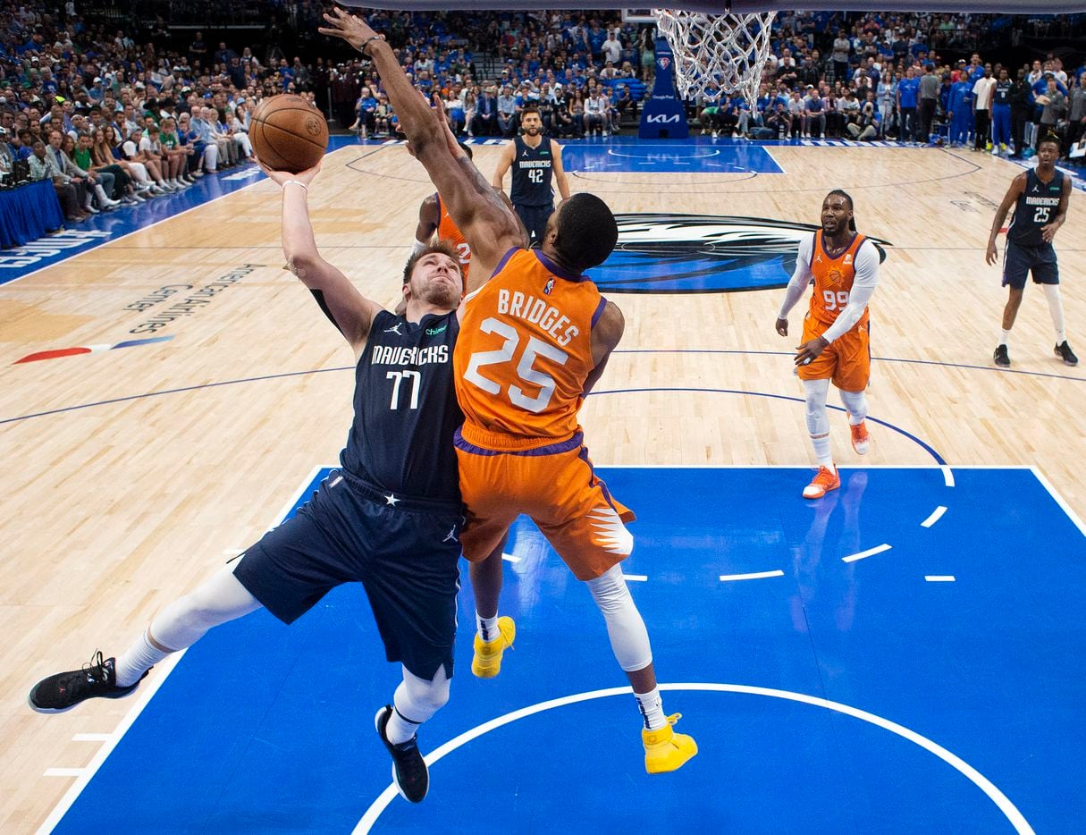 Dallas Mavericks guard Luka Doncic (77) puts up a contested shot against Phoenix Suns...