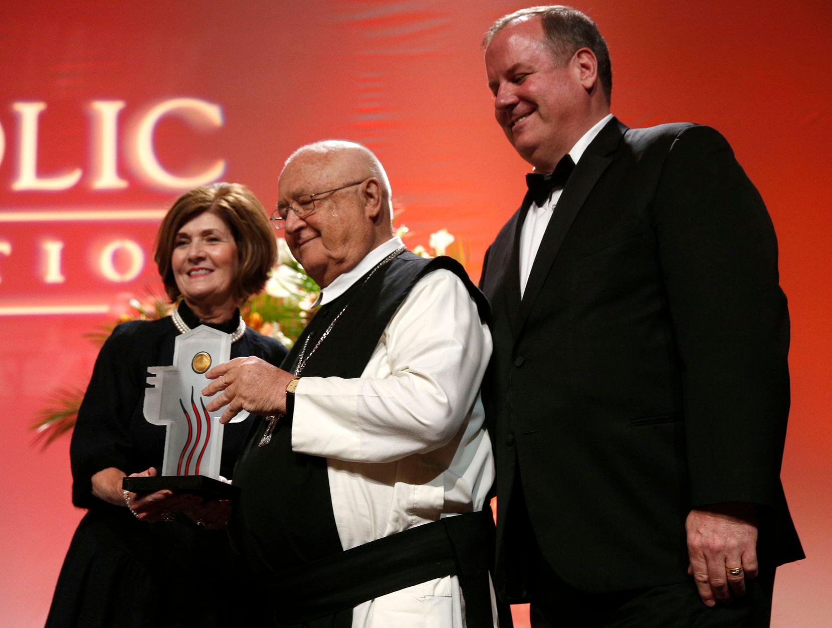 The Rev. Denis Farkasfalvy accepts the honoree award from Victoria Lattner, chairman of the board of trustees for The Catholic Foundation, and Matthew Kramer, president and CEO of The Catholic Foundation, during the group's 2016 award dinner in Dallas.