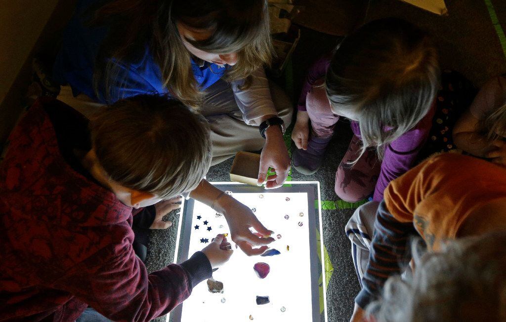 Amy Band shows children items on a lightbox at the Verner Center in Asheville, N.C. Safe...