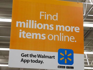 Signs informing customers about Walmart's online shopping at the Walmart Supercenter at Timber Creek Crossing in Dallas.
