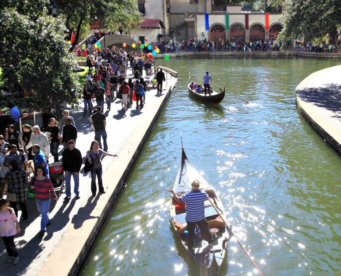 Gondolas move along the water before stopping for passengers at Canal Fest in the Las...
