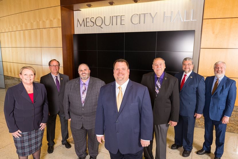 Mesquite Mayor Bruce Archer stands in the center of the city's current city council stands...