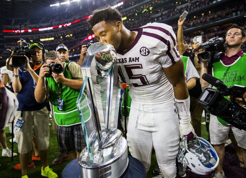 Texas A&M Aggies defensive end Myles Garrett (15) kisses a trophy after a 28-21 win over the...