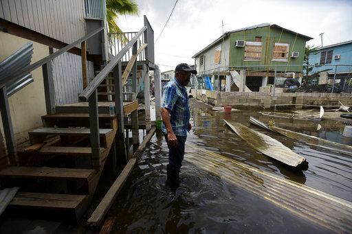 Héctor Rosa atraviesa una zona inundada tras el paso dle huracán María en Juana Matos,...