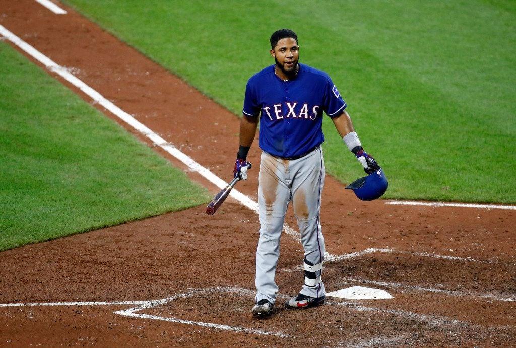 Texas Rangers' Elvis Andrus walks toward the dugout after striking out swinging during the...
