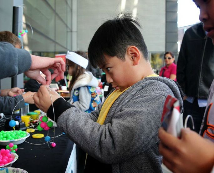 Ethan Truong Nguyen, 9, makes an atom at the DCCCD STEM Institute booth during the Pi Day...
