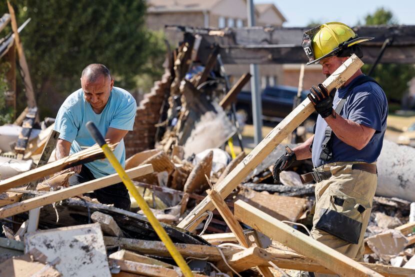 Miguel Quinonez (left) dug through the remains of his house, searching for his passport with...