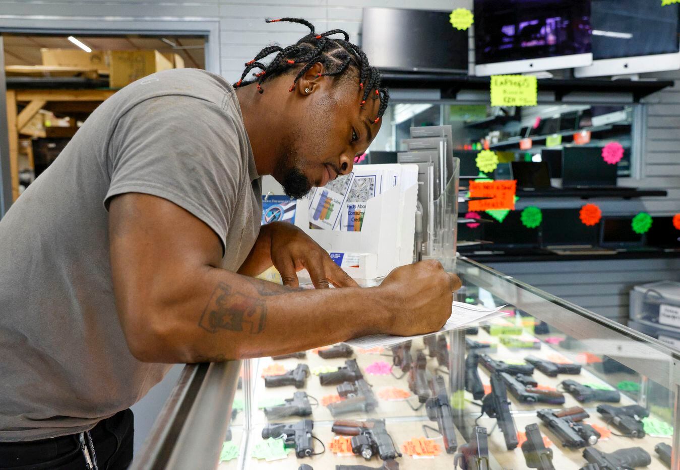 Brian Benford, 31, fills out ATF Form 4473, known as the Firearms Transaction Record, at...