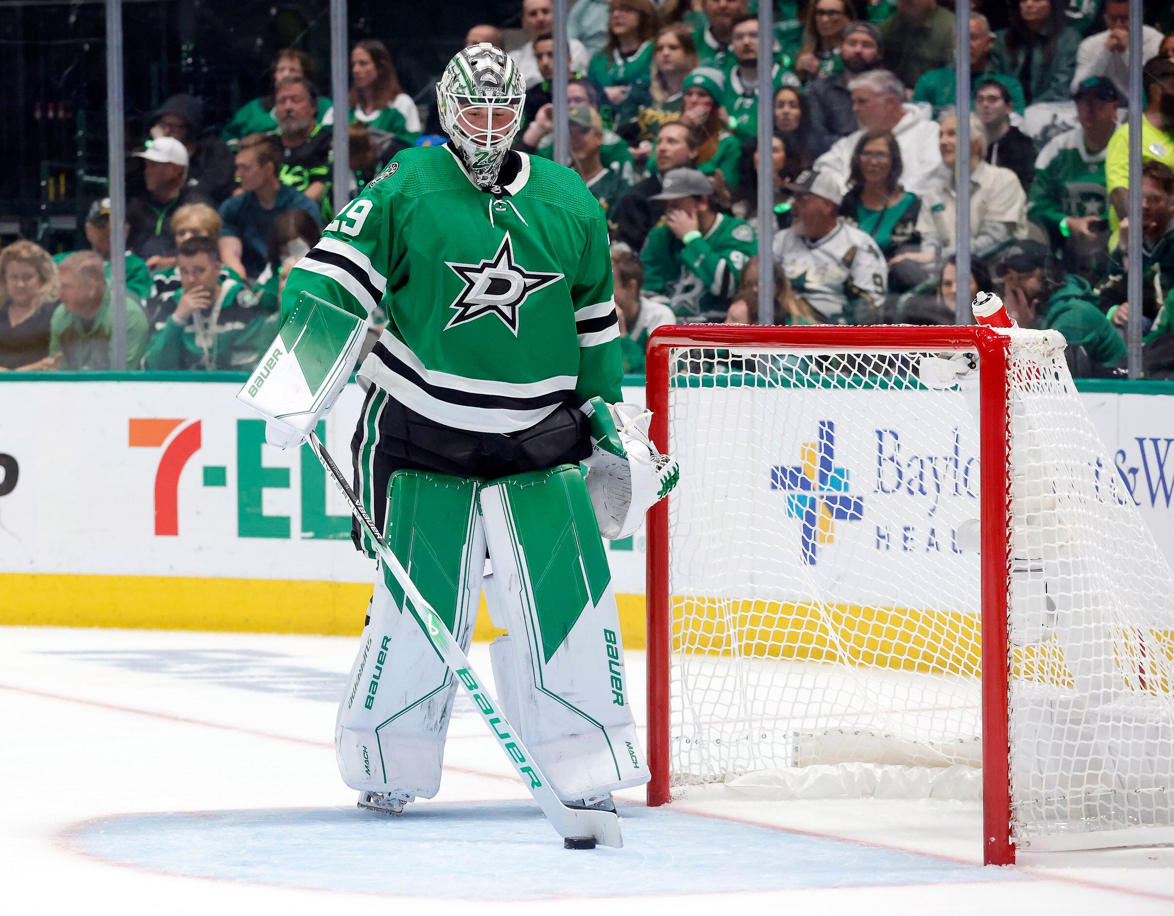 Dallas Stars goaltender Jake Oettinger (29) sweeps the puck from the net after being scored...