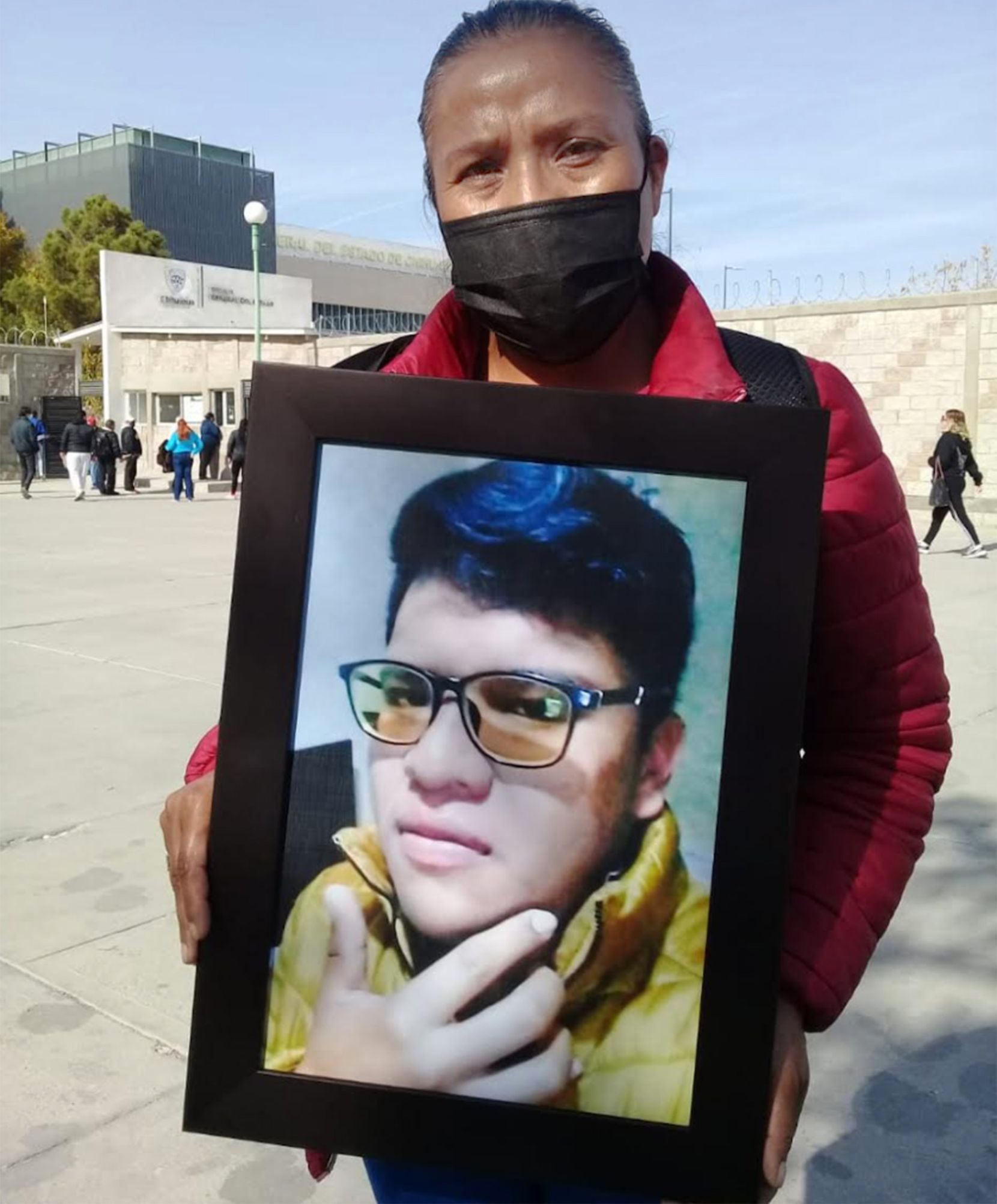 Silvia Reyes Lopez, 42, the mother of Omar Reyes Lopez, holds his picture as she stands outside the Ciudad Juárez prosecutor's office on December 13, 2021. (Sheila Arias/Special Contributor)