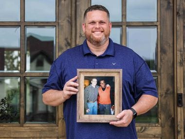 Tyler Tines Pride poses for a portrait outside his home in Lindale as he holds a photo of himself and his father, country music icon Charley Pride.