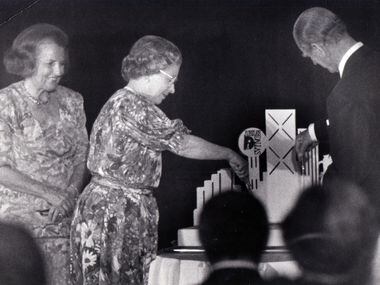 Dallas Mayor Annette Strauss looks on as Queen Elizabeth II and Prince Philip cut a "Jubilee...