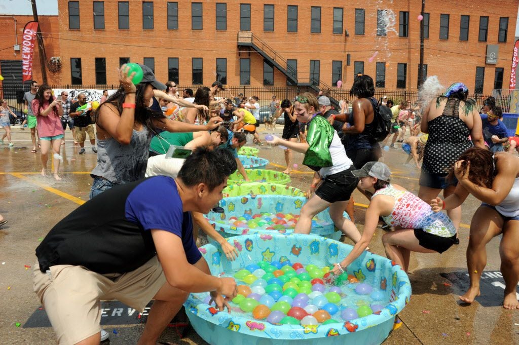 Participants race to grab water balloons at the start of the fight at the Deep Ellum Water...