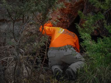 Kelley Janysek, a member of Texas Search and Rescue checks out a small cave Saturday, Oct....