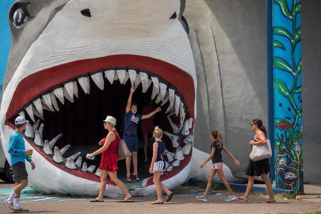 Tourists visit the iconic shark at Destination Beach and Surf shop in Port Aransas on the...