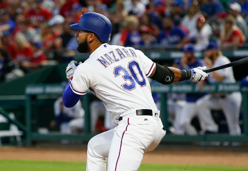 Texas Rangers' Nomar Mazara follows through on his grand slam against the Oakland Athletics...