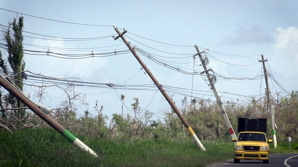 Power lines hang precariously over the weekend on the side of the road on highway 118 near...