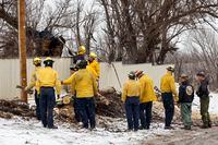 Fire crews from various agencies work to cut down a dead tree to prevent further damage...