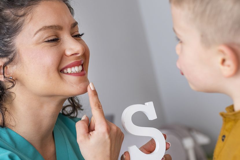 Una terapeuta del lenguaje ayuda un paciente pequeño con el desarrollo del habla.