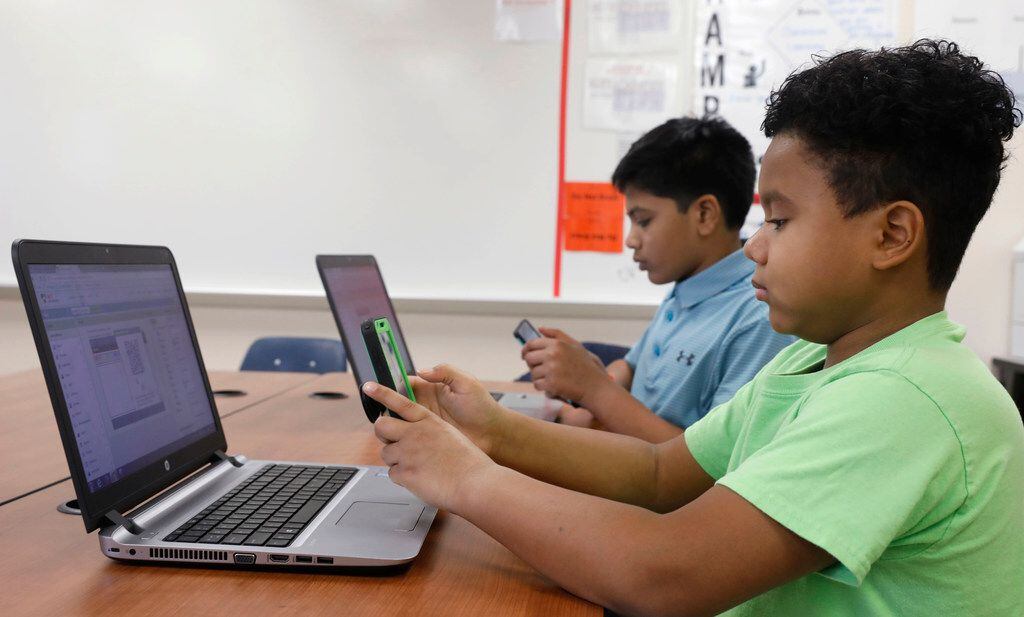 Sixth-graders Hemant Pacha (left), 11, and Mikey Shands, 11, work on their phones and computers in a computer coding club at Barbara Bush Middle School in Irving. They both create an app for games and Mikey has his own YouTube channel. Hemant wants to be a doctor and a part-time video game designer and Mikey wants to be a cartoon animator. 
