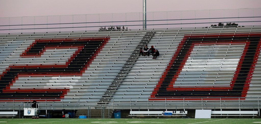 Early arriving North Dallas High fans sit in the middle of a giant number "20" painted on...