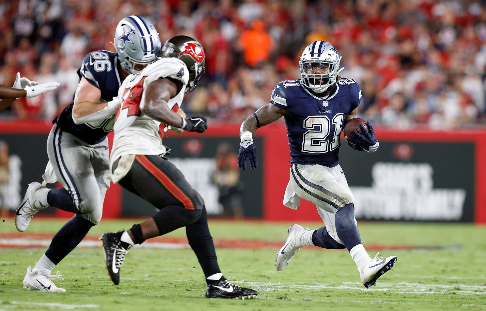 Dallas Cowboys running back Ezekiel Elliott (21) receives a block from tight end Dalton Schultz (86) against the Tampa Bay Buccaneers during the third quarter at Raymond James Stadium in Tampa, Florida, Thursday, September 9, 2021.