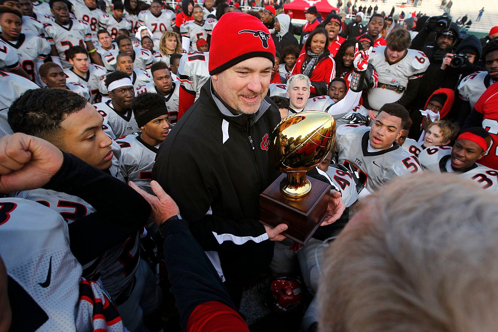 Cedar Hill head coach Joey McGuire accepts the Class 5A Division II state semifinal trophy...