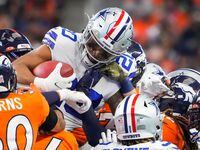 Dallas Cowboys running back Tony Pollard (20) is rapped up by the Denver Broncos return...