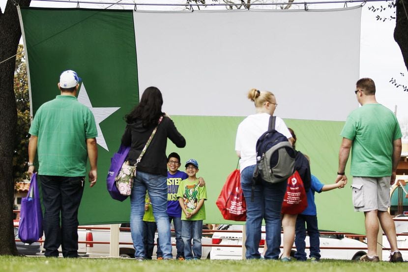 Visitors pose for photos in front of a St. Patrick's day themed Texas flag during the Fort...