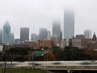 Cars speed down Interstate 35 East as  fog looms over the city skyline of Dallas, Wednesday, Dec. 8, 2021.