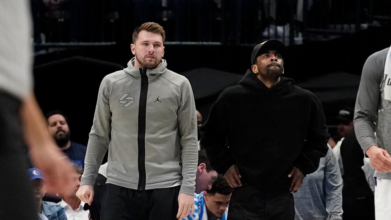 Dallas Mavericks' Luka Doncic, left, and Kyrie Irving look on from the sideline during the...