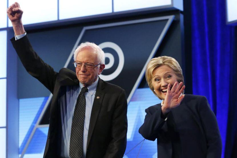 Los candidatos del partido Demócrata Bernie Sanders y Hillary Clinton saludan al público...