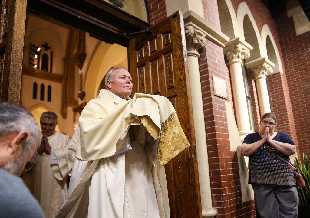 Bishop Edward Burns processes with the eucharist during a Mass of the Lord's Supper at...