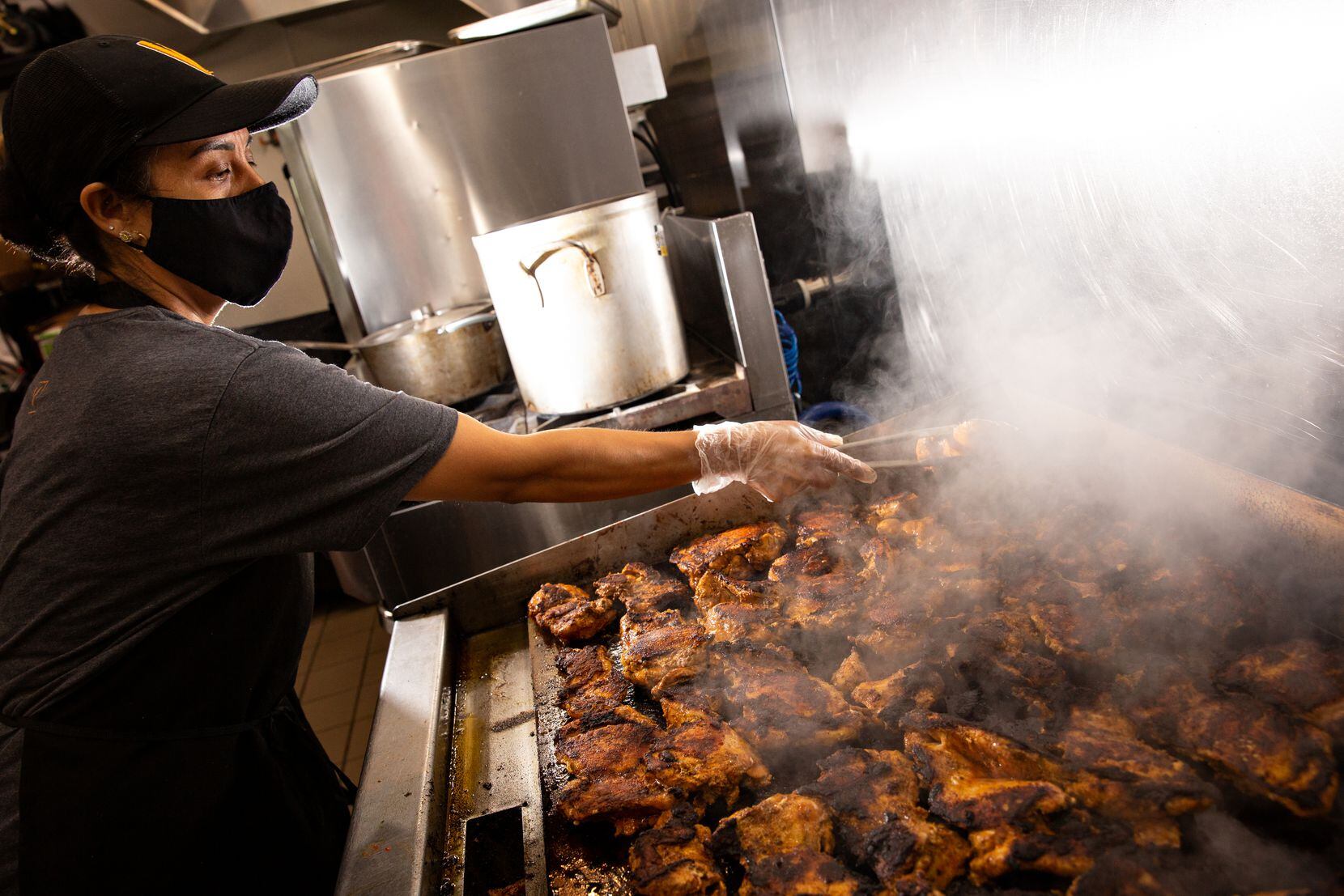 Maria Hernandez, a cook at Cava, grills chicken to be used in Mediterranean bowls, salads or...