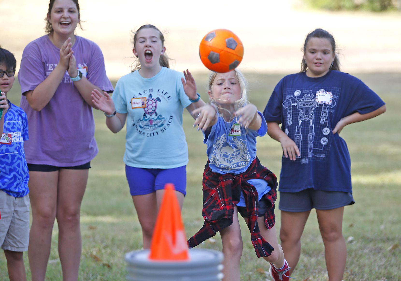 Vanna Green (second from right), 10, of Plano, throws a ball in an attempt to knock down a cone...