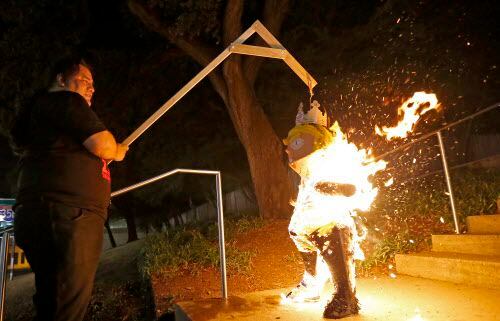 Leroy Peña quema una piñata del presidente Donald Trump al final de una protesta organizada...