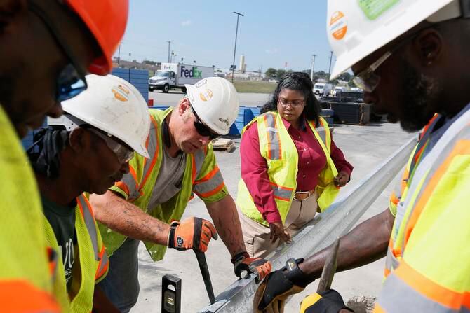 Eve Clark, the owner and CEO of MEB Construction, supervises the installation of guardrails...