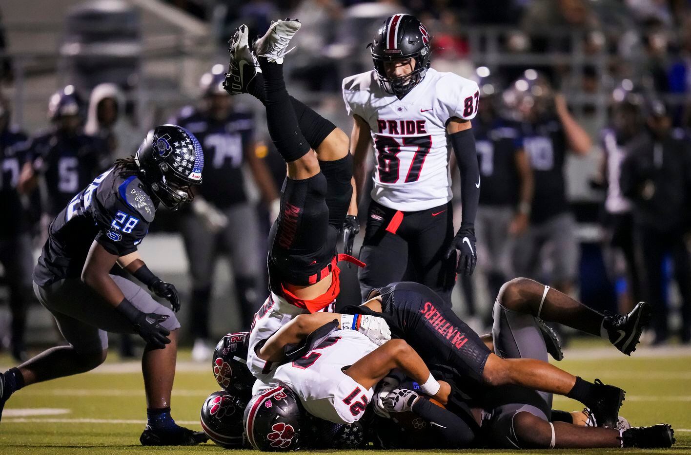 Colleyville Heritage running back Riley Wormley (27) tumbles over the pile as linebacker Soane Tavo (21) brings down Mansfield Summit’s Ahmaad Moses (3) during the first half of the Class 5A Division I Region I final on Friday, Dec. 3, 2021, in North Richland Hills, Texas. (Smiley N. Pool/The Dallas Morning News)