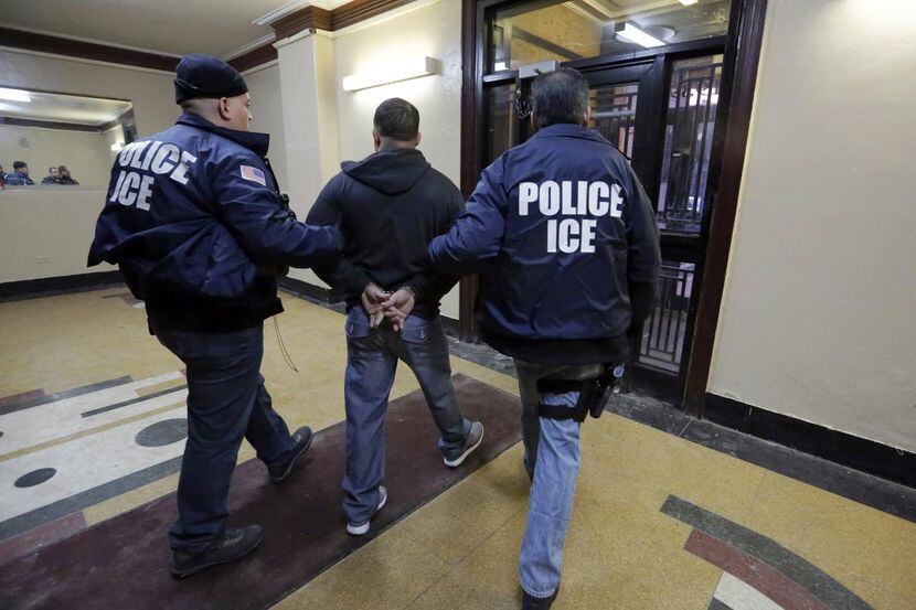 En esta foto del 3 de marzo del 2015, agentes de ICE llevan detenido a una persona en el...
