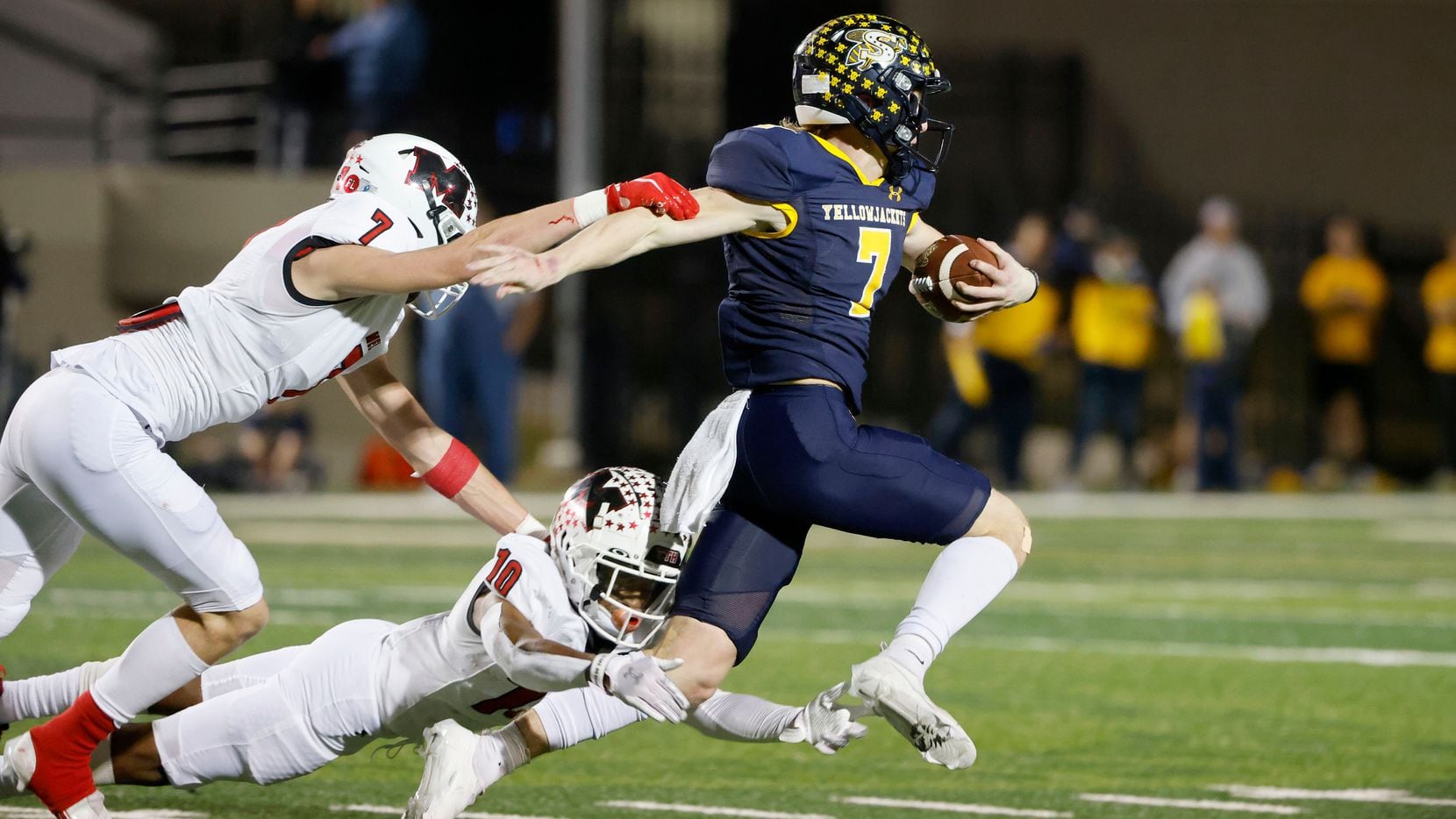 Melissa’s Gunnar Wilson (7) and Parrish Adger (10) tackle Stephenville quarterback Ryder Lambert (7) during the first half of a Class 4A Division I Region II final high school football game in Bedford, Texas on Friday, Dec. 3, 2021. (Michael Ainsworth/Special Contributor)