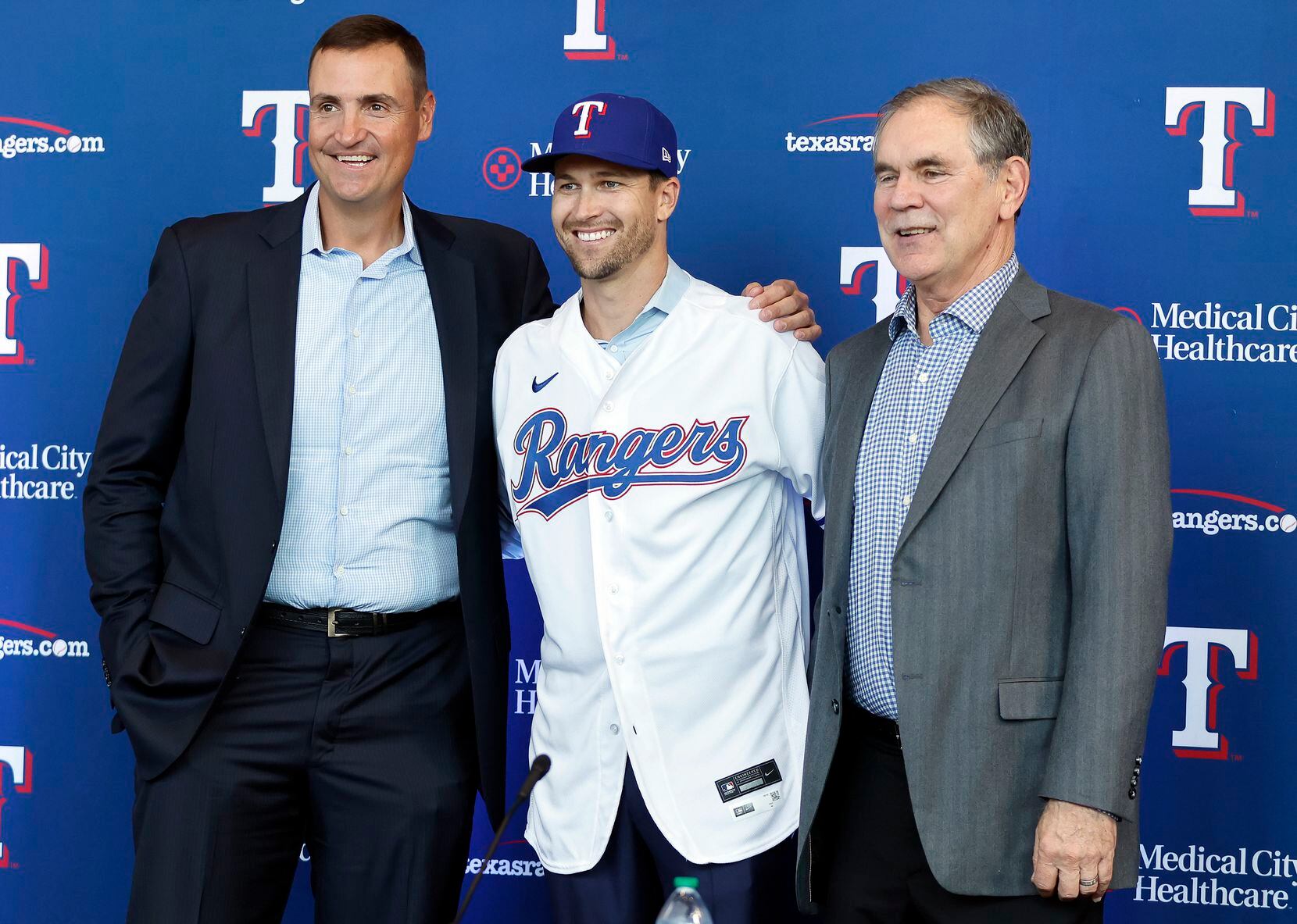 New Texas Rangers starting pitcher Jacob deGrom (center) poses for photos with new manger...