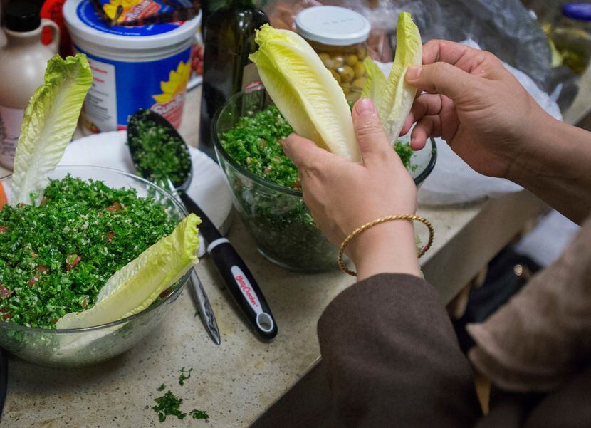 Mariam Alshiblaq, a Syrian refugee, prepares tabbouleh at the Leah's Kitchen annual...