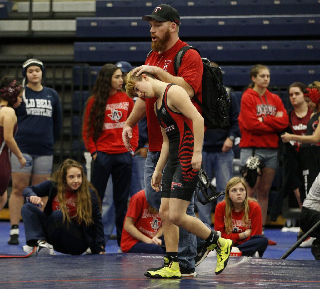 Euless Trinity's Mack Beggs (front) walks off the mat with coach Travis Clark after Beggs'...