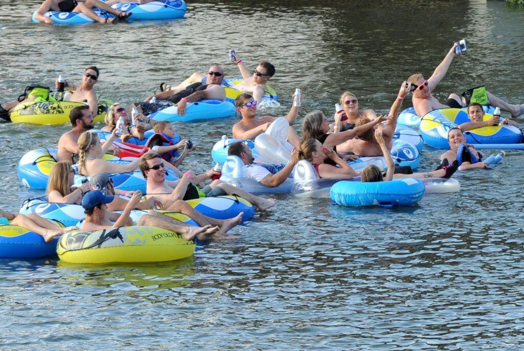 Attendants float in the Trinity river and listen to local music by Josh Weathers Band at the...