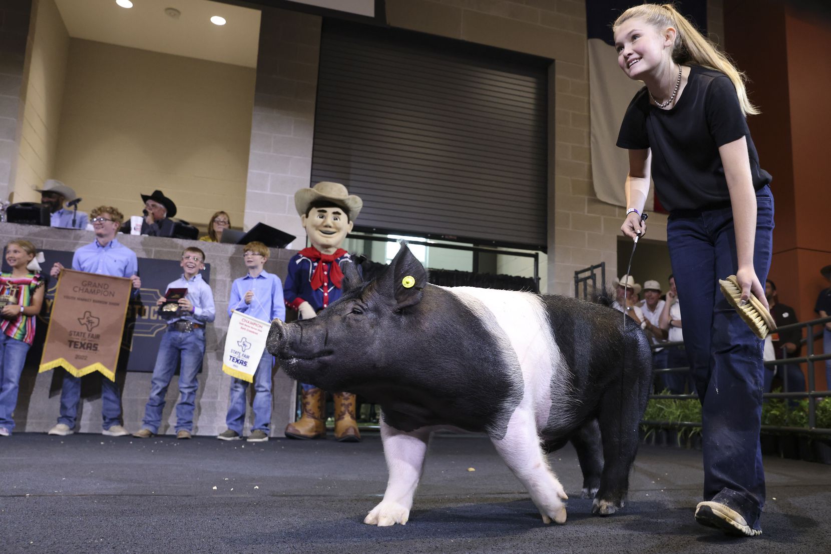 Camryn Clift shows her grand champion market barrow at the State Fair of Texas on Friday.