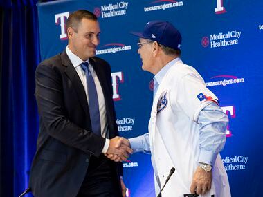 Chris Young (left), the team's executive vice president and general manager, shakes hands...